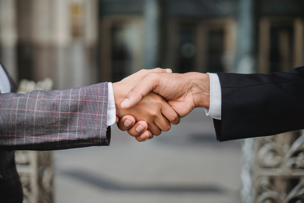 A hard money lender shaking hands with his client after a successful deal