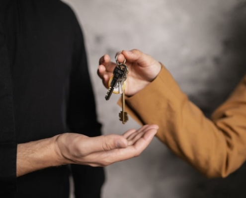 A person handing a house key to another person