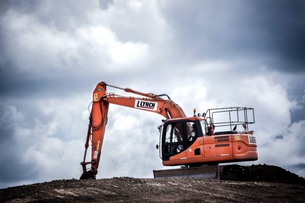 An orange excavator conducting construction work