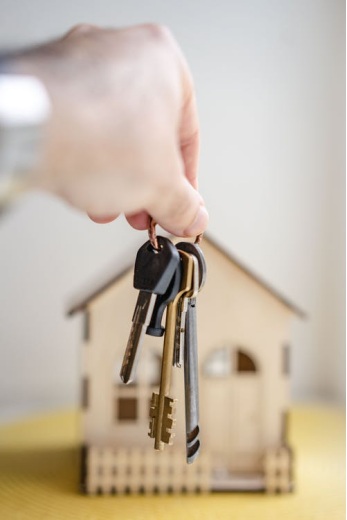a bunch of keys in front of a miniature house