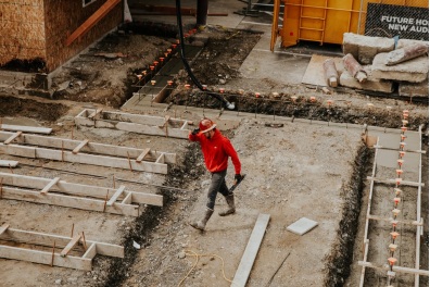 a person in a red shirt and helmet on a construction site