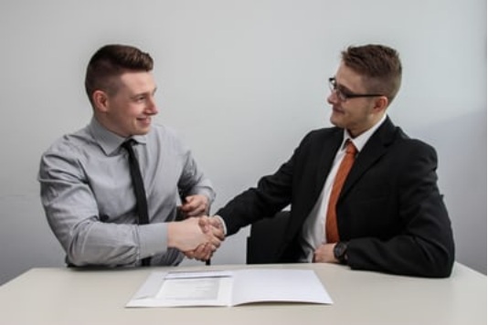 two men shaking hands finalizing a contract